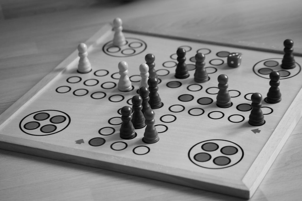 Black and white image of a board game with chess pieces and dice.